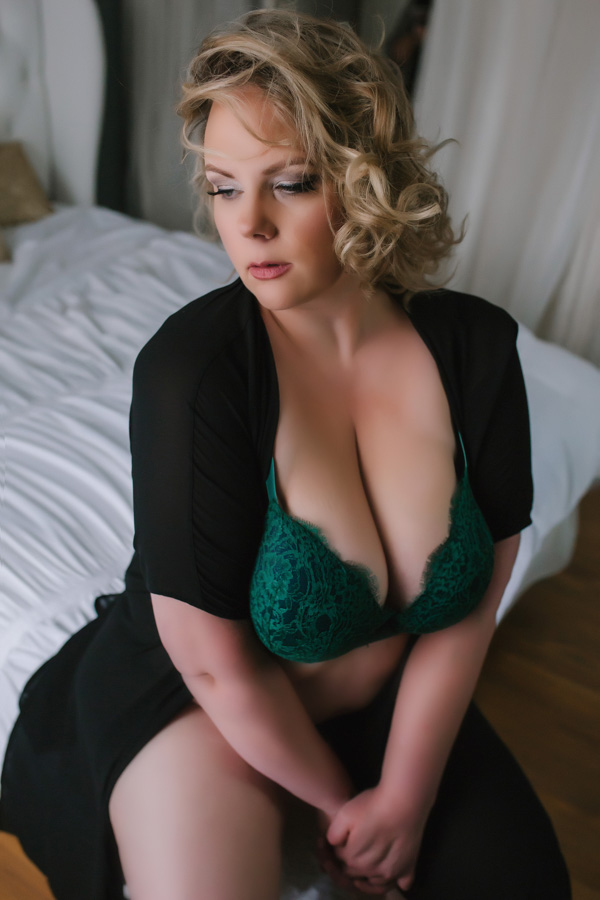pittsburgh boudoir photographer, Maura Chick, poses in her own studio with photos by Miranda Parker Boudoir