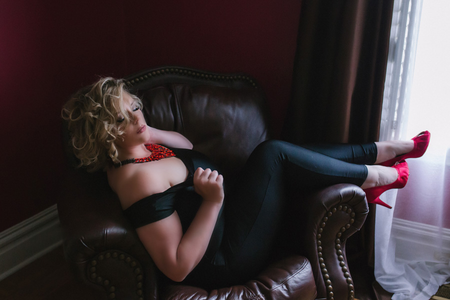 pittsburgh boudoir photographer, Maura Chick, poses in her own studio with photos by Miranda Parker Boudoir