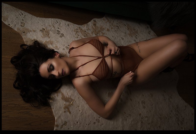 pittsburgh boudoir photos woman in orange bodysuit posing on sofa at pics by chicks photography pittsburgh boudoir photos woman in orange bodysuit posing on sofa at pics by chicks photography