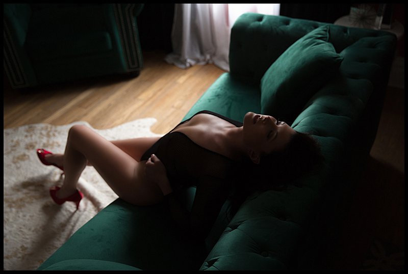 boudoir photography pittsburgh woman in fishnet bodysuit on studio sofa boudoir photography pittsburgh woman in fishnet bodysuit on studio sofa