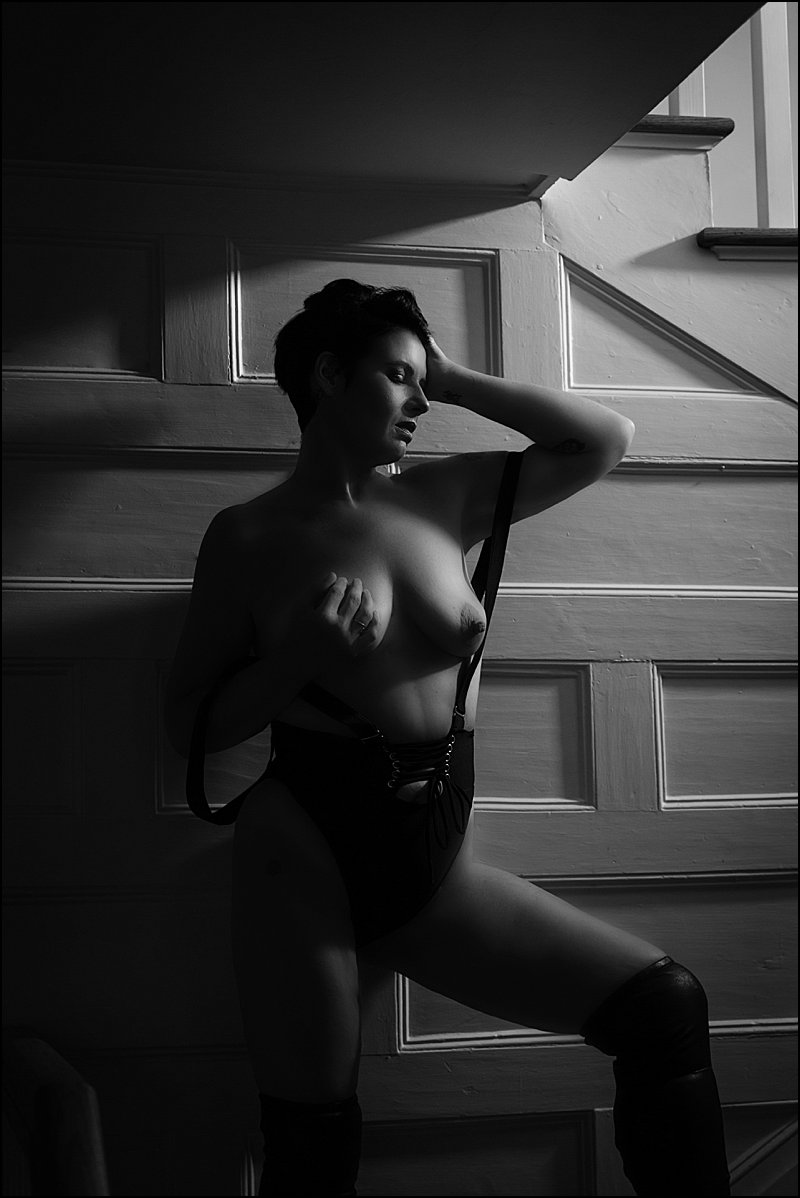 boudoir sexy photos by maura chick of woman in black suspender lingerie on steps at boudoir studio in pittsburgh