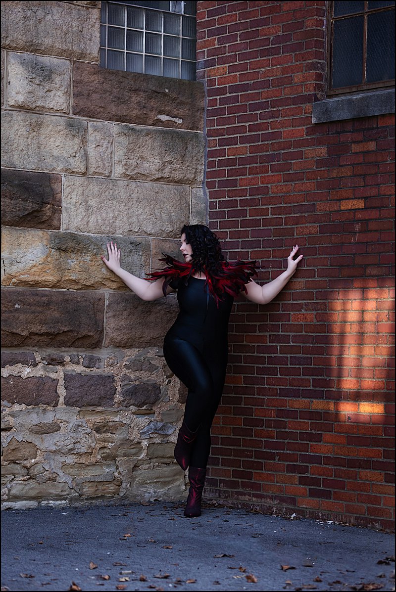 Outdoor boudoir photo shoot in Pittsburgh, Maura Chick Studios, client in feather collar with black bodysuit posing outside