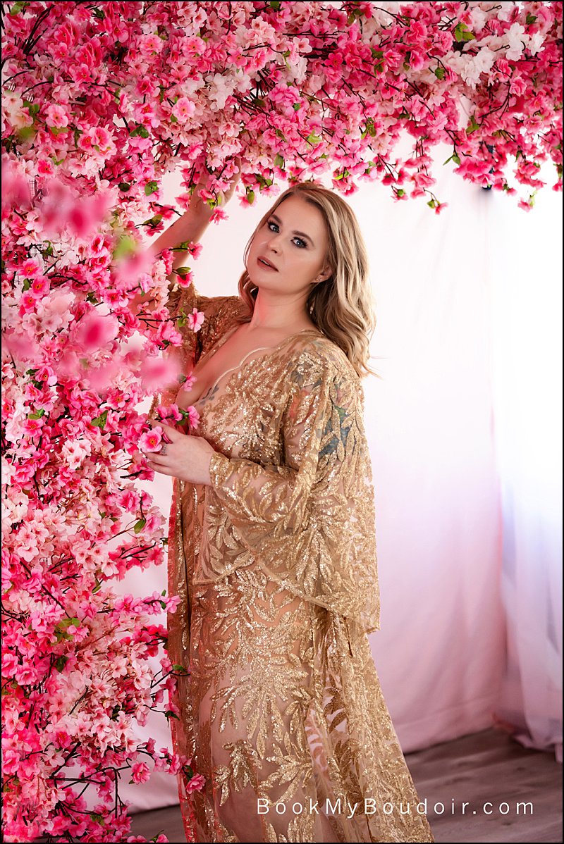 self love photo shoot pittsburgh, cherry blossom photo set at pittsburgh boudoir studio, woman in gold lace gown with flowers